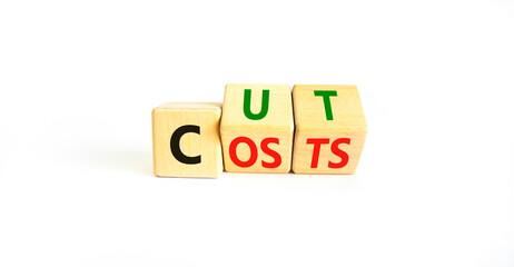 Cut costs symbol. Concept words Cut costs on wooden cubes. Beautiful white table white background. Cut costs and business concept. Copy space.