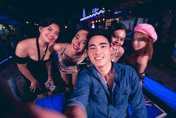Five young friends take fun selfies while partying at a nightclub or bar. 5 people having a great...