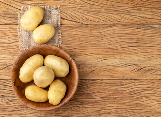 Potatoes in a bowl over wooden table with copy space