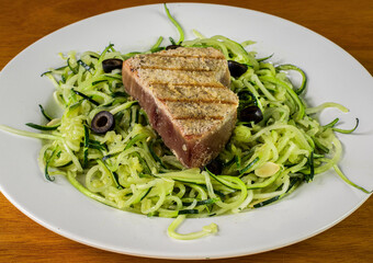 tuna  steak with zucchini noodles and black olives