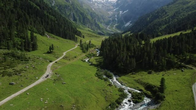 Drone aerial view from Lüsens valley with a river and the high mountains of Austria in the background in summer