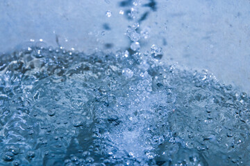 The turquoise water had water droplets falling from above causing ripples.