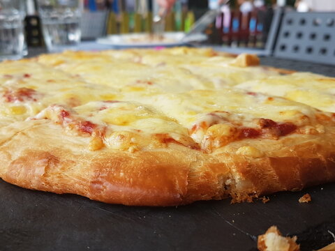 pizza with chees on black wooden table