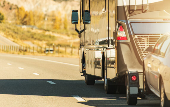 RV Motor Coach With Pull Vehicle On A Highway