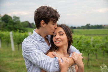 Boyfriend gives a kiss on the forehead of his girlfriend, passionate moment, they are outside. They love each other