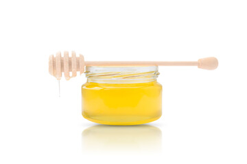 jar of fresh bee honey with a wooden stick