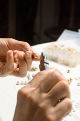 person using a round nose pliers on a metal wire, home crafts concept