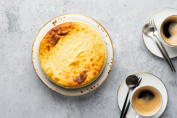 Breakfast concept. Top view of acottage cheese casserole with cups of coffee on a concrete light...