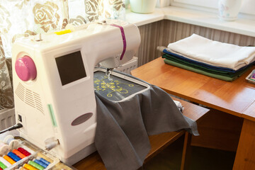 Home sewing workshop, workplace, with a modern embroidery machine.
