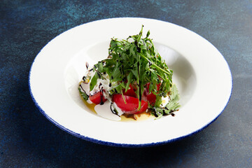 Salad with arugula, tomatoes and ricotta cheese.