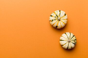 Autumn composition of little orange pumpkins on colored table background. Fall, Halloween and Thanksgiving concept. Autumn flat lay photography. Top view vith copy space