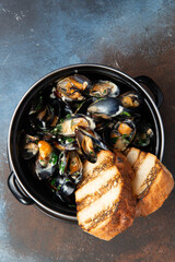 Cooked mussels and fried bread in a pan.