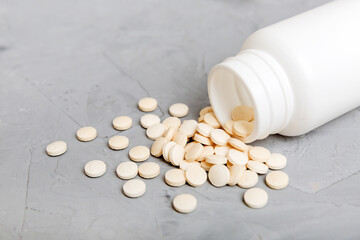 different drugs and health supplement pills poured from a medicine bottle health care and medical top view on colored background