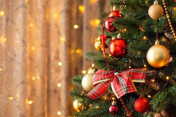 Bright decorated christmas tree. Close-up photo of a Christmas tree decorated with a bow, red and...