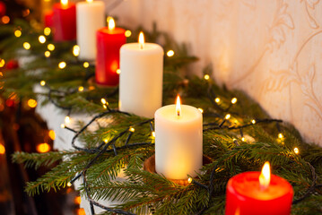 Close up of burning red and white candles on the piano. Christmas decorations at home, festive atmosphere