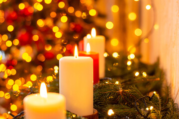 Burning candles on the background of christmas tree lights. Beautiful Christmas decorations
