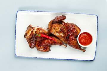 Fried chicken in a plate on a gray background.