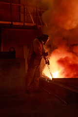 Fototapeta na wymiar Man works in blast furnace workshop.
