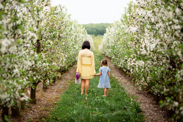 Vinnytsia, Ukraine. May 18, 2021. Mom and daughter walk in the flower garden