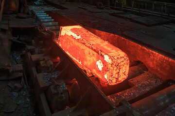 Hot red steel slabs in iron foundry workshop.