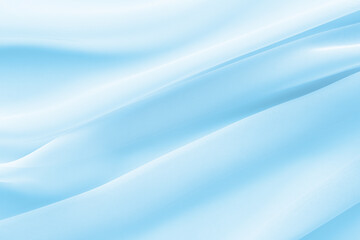 light blue fabric draped with diagonal folds, delicate textile background