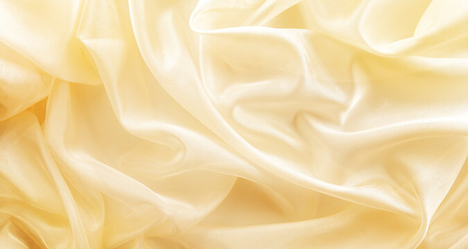 shiny golden fabric draped with folds, textile wave background