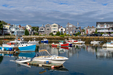 Fototapeta na wymiar Rockport - A sunny Autumn morning view of colorful fishing boats docking in the peaceful inner harbor of Rockport, a small seaside resort town at tip of Cape Ann, near Boston, Massachusetts, USA.