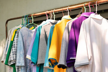 Colorful adult male clothes hanging on old clothes line with sunlight
