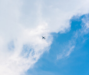 Airplane flying in the sky with white clouds