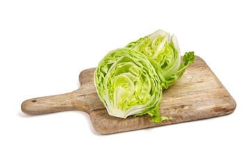 Iceberg lettuce halved head on wooden cutting board, fresh leafy green vegetable isolated on white