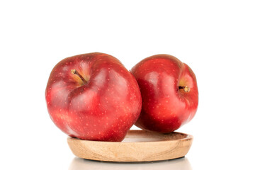 Two ripe red apples on a wooden saucer, close-up, isolated on a white background.