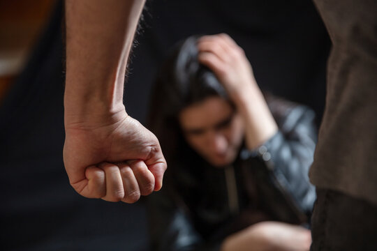 Woman abuse, Young woman scared, male clenched fist close up. Domestic violence