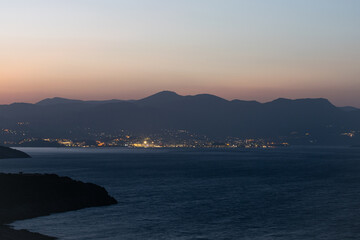 Sunset over the sea and a view of the city of Agios Nikolaos
