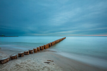 Naklejka premium Amazing sunrise over the beach in Chalupy. Seascape with breakwater
