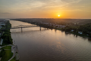 Sunset Over a River and Bridge next to Small Town