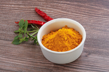 Yellow vibrant curcuma powder in the bowl