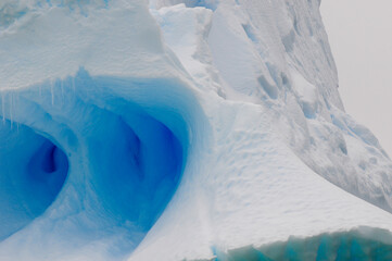 close up of icebergs bright blue hues in the sea