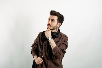 Obraz premium Portrait of casual young man wearing casual clothes posing isolated over white background serious face thinking about question, very confused idea