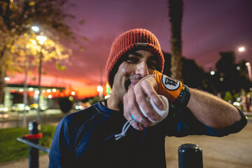 Portrait of a smiling, healthy, handsome, and fit young latin man with wool cap and wristbands...
