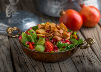 Fatoush served in dish side view on wooden table background