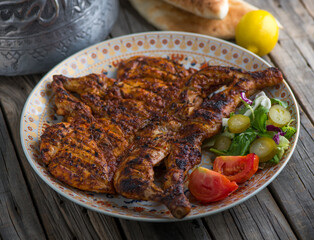 grilled whole chicken served in dish side view on wooden table background