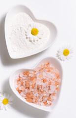 Mineral cosmetic clay and pink Himalaya salt on white background close up.