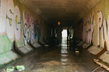 Men in a graffiti Waterway tunnel