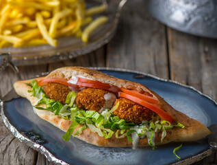 Falafel Sandwich served in dish side view on wooden table background