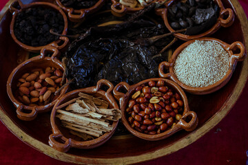 Fototapeta na wymiar Ingredients to prepare the traditional mole poblano from San Lucas Atzala: peanuts, cinnamon, chili and chocolate