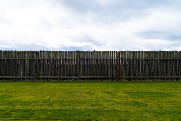 Wooden fence and blue sky with green grass