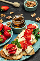 Bruschetta Sandwich with sstrawberries, cheese camembert nuts and honey basil, served as an appetizer