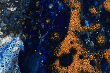 Abstract blue and gold bubble blot and drops background. Marble texture. Acrylic color in water and oil.