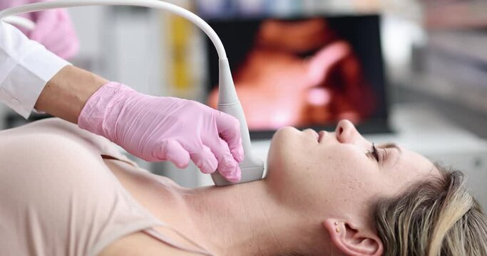 Young caucasian woman undergoes ultrasound of thyroid gland in office of female doctor