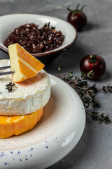Camembert, Brie, Gorgonzola and blue cream cheese with thyme and onion marmalade jam. French cuisine. An aperitif on a gray background. place for text, top view